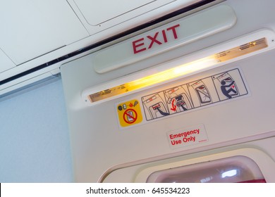 Exit Sign And Symbols Over The Door In An Aircraft Cabin