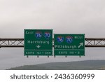 Exit signs for Interstate 76 and Interstate 70, East toward Harrisburg, Pennsylvania and West toward Pittsburgh, Pennsylvania