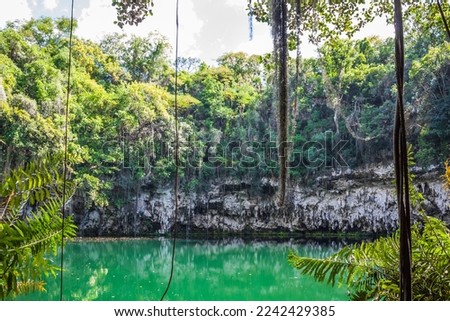 Exit from the water cave in the jungle to a small lake surrounded by mountains. Beautiful tropical nature. Observation platform under the vaults of the cave