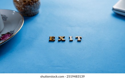 EXIT; Wooden letters with "EXIT" text of concept. isolated on blue background - Powered by Shutterstock