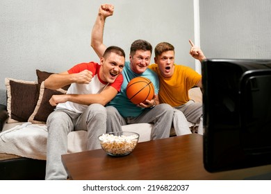 Exited Family, Father And Two Sons Watching Basketball Game And Cheering 