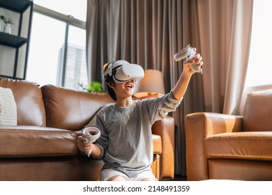 exiting asian child male boy enjoy metaverse gaming with wearable vr headset with control handle playing sport gaming online in living room at home,home technology young teen using vr technology - Powered by Shutterstock