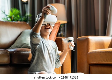 exiting asian child male boy enjoy metaverse gaming with wearable vr headset with control handle playing sport gaming online in living room at home,home technology young teen using vr technology - Powered by Shutterstock