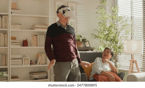 exiting asian senior old man white beard enjoy virtual augmented reality metaverse explore online digital world game in living room at home,casial relax old man play digital leisure game at home  - Powered by Shutterstock