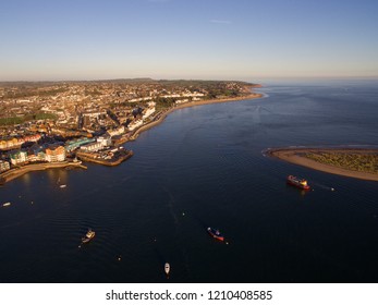 Exmouth and the Exe estuary in Devon from above by drone, on a sunny evening, with boats moored up . 