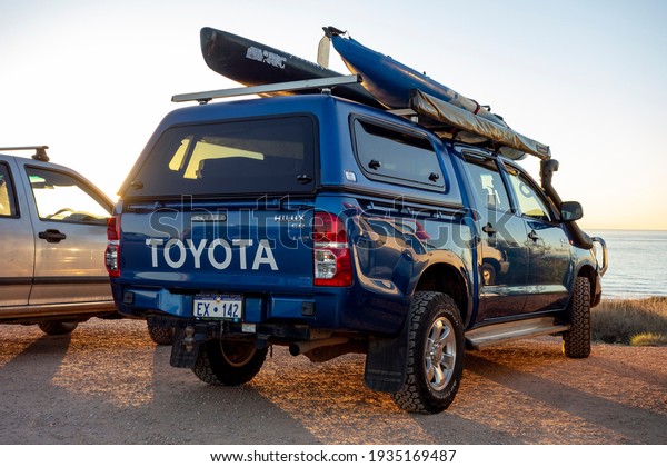 EXMOUTH, WESTERN AUSTRALIA - JULY 7, 2018: The\
blue Toyota Hilux 3.0 D-4D pickup in Western Australia with\
adveture equipment at\
sunset