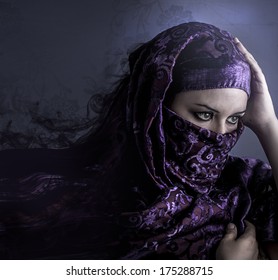 Exotic arab woman looking outside. artistic portrait with handmade tattoo tribals, blue tone in the background