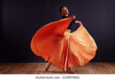 Exotic Expression. Female Contemporary Dancer In A Dramatic Pose Against Dark Background.