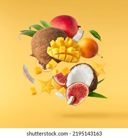 Exotic fruit mix, coconuts, mango, fig, passiflora, carambola falling in te air isolated on yellow background. Food levitation, zero gravity conception. High resolution image - Shutterstock ID 2195143163