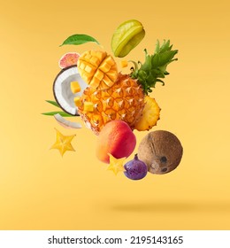 Exotic fruit mix, pineapple, coconuts, mango, fig, passiflora, carambola falling in te air isolated on yellow background. Food levitation, zero gravity conception. High resolution image - Shutterstock ID 2195143165