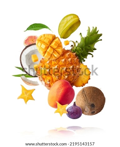 Exotic fruit mix, pineapple, coconuts, mango, fig, passiflora, carambola falling in te air isolated on white background. Food levitation, zero gravity conception. High resolution image
