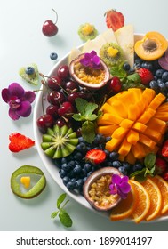 Exotische Früchte Mango, Passionsfrucht, Heidelbeere und Erdbeeren auf Teller auf weißem Hintergrund