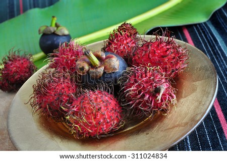 exotic fruits rambutan and mangosteen on golden plate