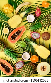 Exotic fruits and tropical palm leaves on pastel yellow background - papaya, mango, pineapple, banana, carambola, dragon fruit, kiwi, lemon, orange, melon, coconut, lime. Top view - Shutterstock ID 1106132531