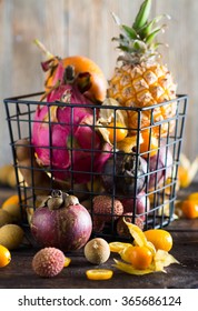 Exotic Fruits Variety In A Wire Basket On A Dark Wooden Background