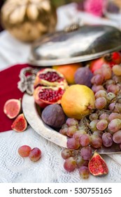 A lot of exotic fruits at a vintage plate served on a white and red linen. Creative vintage feast decoration.
