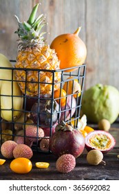 Exotic Fruits In A Wire Basket On A Dark Wooden Background.