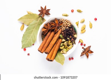 Exotic herbal Food concept Mix of the organic Spices cinnamon stick, cardamom pods, bay leaves, star anise and coriander seedsin white ceramic cup on white background - Shutterstock ID 1091873207