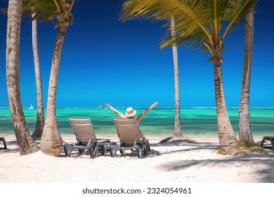 Playa de isla exótica con palmeras y soláriums en la costa del mar Caribe, vacaciones tropicales de verano.