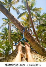 Exotic Island Chilling View Of Legs And Sand. Tropical Palms, Someone Sitting And Enjoy The Vacation. 1st Person View.