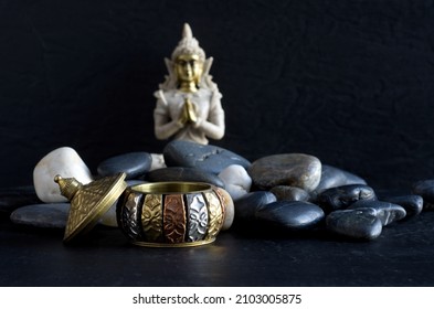 Exotic Round Container with Rocks and Blurred Gautama Buddha in the Background Horizontal