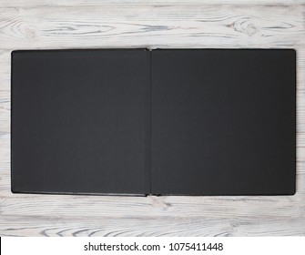 Expanded family photo book in a leather cover on a wooden background.
Wedding photo album.
black photobook on a wooden background.
Open photo book pages. open album turns