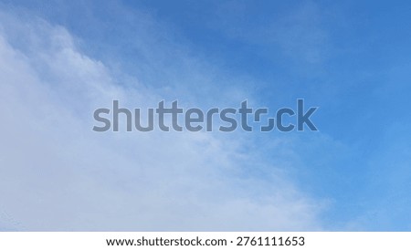 Expansive blue sky featuring delicate white cirrus clouds; perfect for background or overlay projects; conveying serenity and natural beauty.