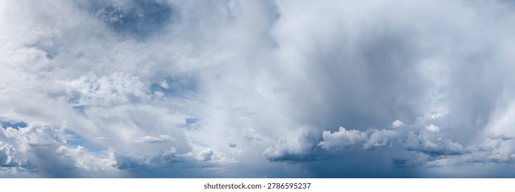 Expansive cloudscape of dramatic storm and rain shafts beneath a moody blue sky showcasing atmospheric weather.