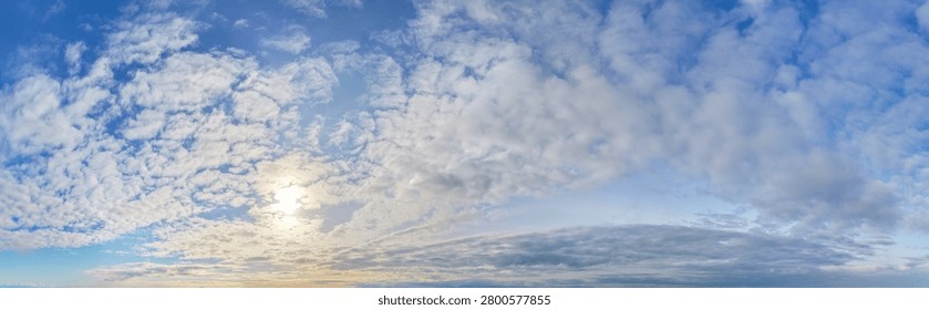 Expansive cloudscape sky in BC, Canada with sunlight filtering through layered clouds over a tranquil horizon.