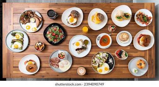 An expansive and colorful array of various breakfast items arranged on a wooden table, showcasing a diverse and appetizing morning meal selection