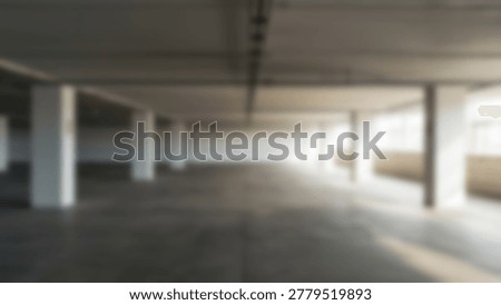 An expansive concrete parking structure featuring numerous support columns, providing a sense of depth and perspective. The image captures the interplay of light and shadow.