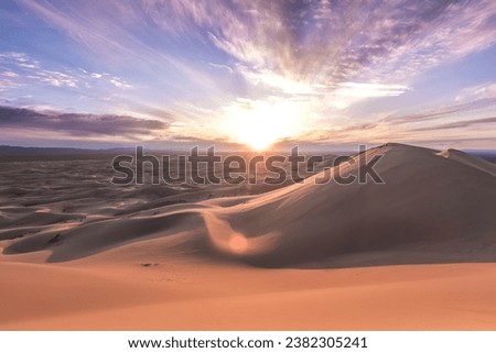 Expansive Desert Landscape: A tranquil vista of golden dunes stretching to meet the infinite horizon under a pristine blue sky, capturing the timeless beauty of the desert