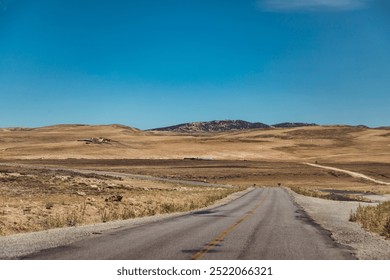 Expansive Desert Landscape With a Winding Road Under a Clear Blue Sky in Morocco's Highlands - Powered by Shutterstock