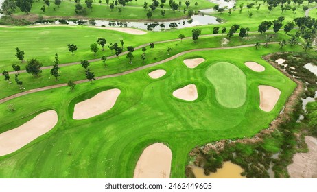 An expansive golf course from an aerial perspective, featuring lush fairways, neatly arranged sand traps, several water bodies, and a rich canopy of trees.
 - Powered by Shutterstock