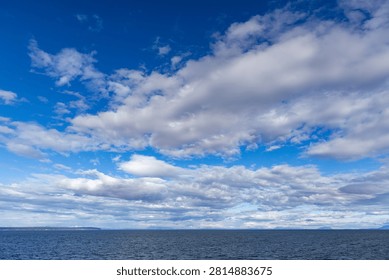 Expansive ocean and dramatic cloud-filled sky over the Strait of Georgia, British Columbia, Canada, a peaceful coastal seascape.
