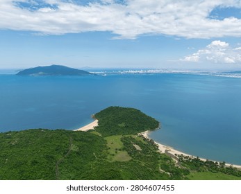 Expansive panoramic view from Hai Van Pass shows green headlands, sandy beaches, Son Tra Peninsula, and Da Nang skyline across turquoise bay.