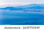 Expansive seascape with an urban shoreline. Serene waters meet a bustling city