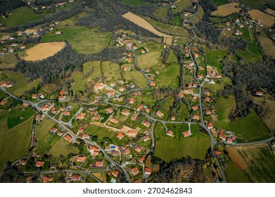 An expansive view of the charming Pays Basque region in France showcases lush green fields, small villages, and winding roads.