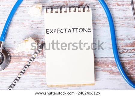 EXPECTATIONS the text is written on a notebook that lies on old vintage boards