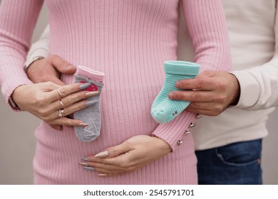 Expecting Parents Displaying Baby Socks on Pregnant Belly. - Powered by Shutterstock