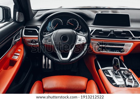 Expensive car interior with steering wheel, multimedia dashboard and gearbox handle. 