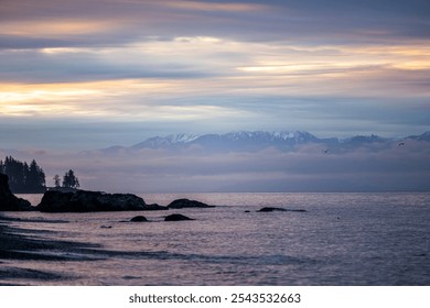 Experience the calming beauty of sunrise over Vancouver Island. The gentle waves and misty mountains create a serene and peaceful seascape, ideal for promoting tranquility and natural wonder. - Powered by Shutterstock