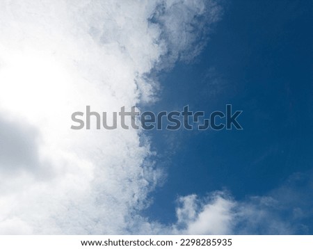 Experience the captivating beauty of fluffy white clouds drifting across a brilliant blue sky with this remarkable image. The high-resolution photograph showes the ethereal charm of nature