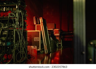 Experience the electrifying anticipation of live music with this stock image. Warm, moody lighting showcases concert equipment and cases - Powered by Shutterstock
