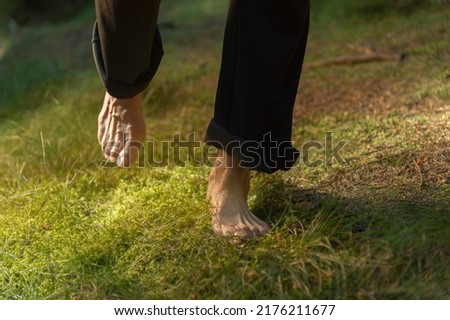 Experience the forest while bathing in the forest (Shinrin Yoku) with all your senses. The bare feet of a woman are walking carefully on soft moss. The sun warms the forest floor. Be h3althy.