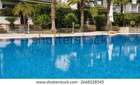 Experience the refreshing allure of this inviting swimming pool surrounded by lush greenery. Ideal for vacation rentals, promoting relaxation and leisure in a serene atmosphere.