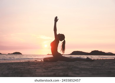 Experience the serene beauty of yoga on the beach at sunset, with a silhouette of a woman stretching her arms and legs - Powered by Shutterstock