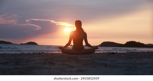 Experience the serene beauty of yoga on the beach at sunset, with a silhouette of a woman stretching her arms and legs - Powered by Shutterstock