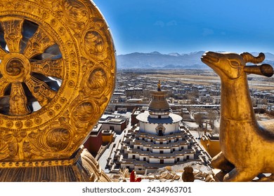 Experience serenity amidst the ancient splendor of Gyantse, Tibet, as the golden Dharma Wheel gleams beside majestic deer statues, framed by the iconic Palcho Monastery.  - Powered by Shutterstock