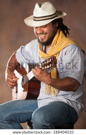 Experience the soulful melodies of a talented Rastafarian musician playing a classic guitar in a high quality studio shot.(124)